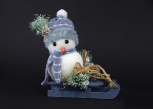 Новорічне прикраса сніговик в шапочці на санках