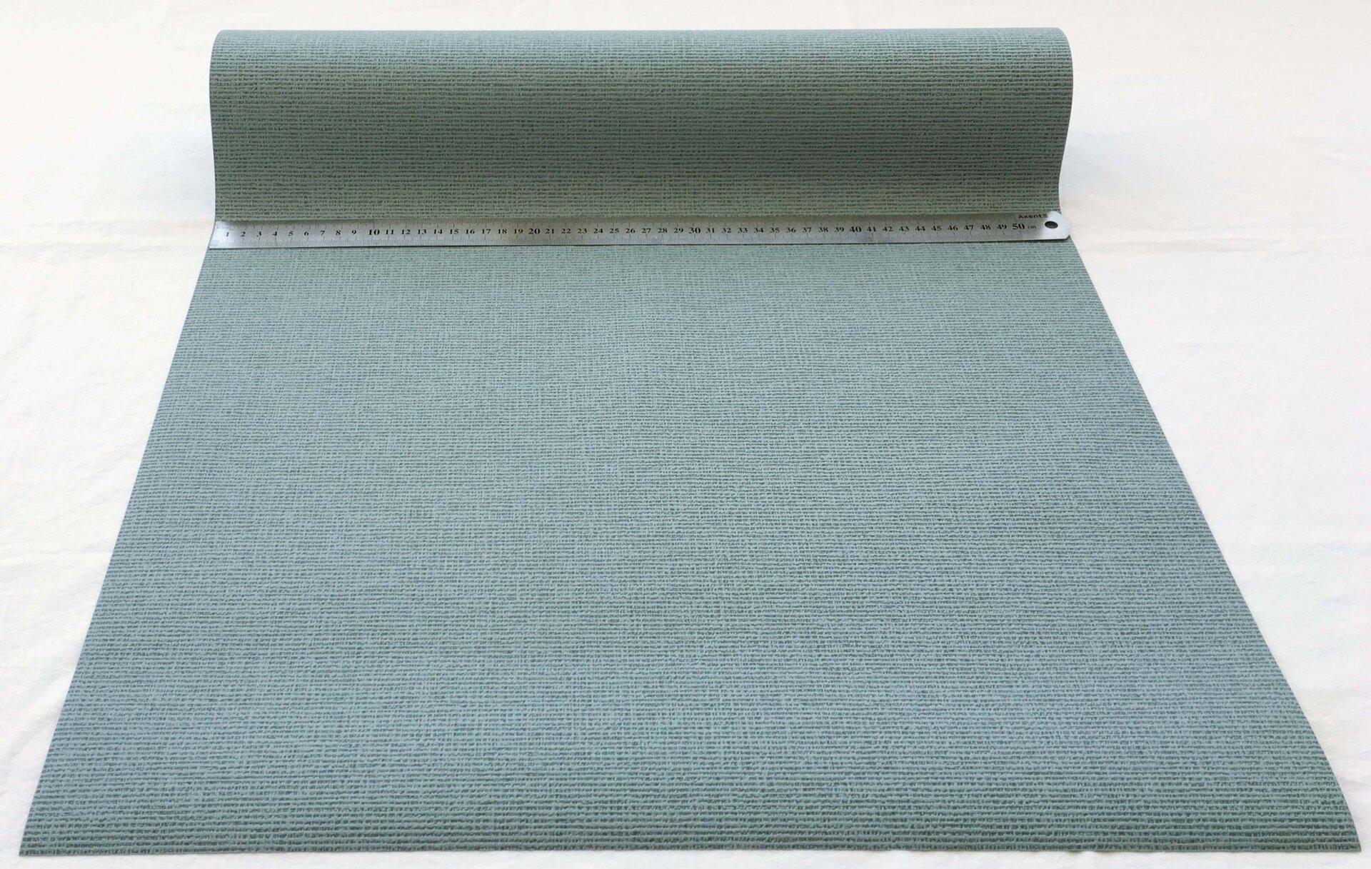 Розгорнутий рулон сіро-бірюзових шпалер AS Creation з виразною текстурою тканини